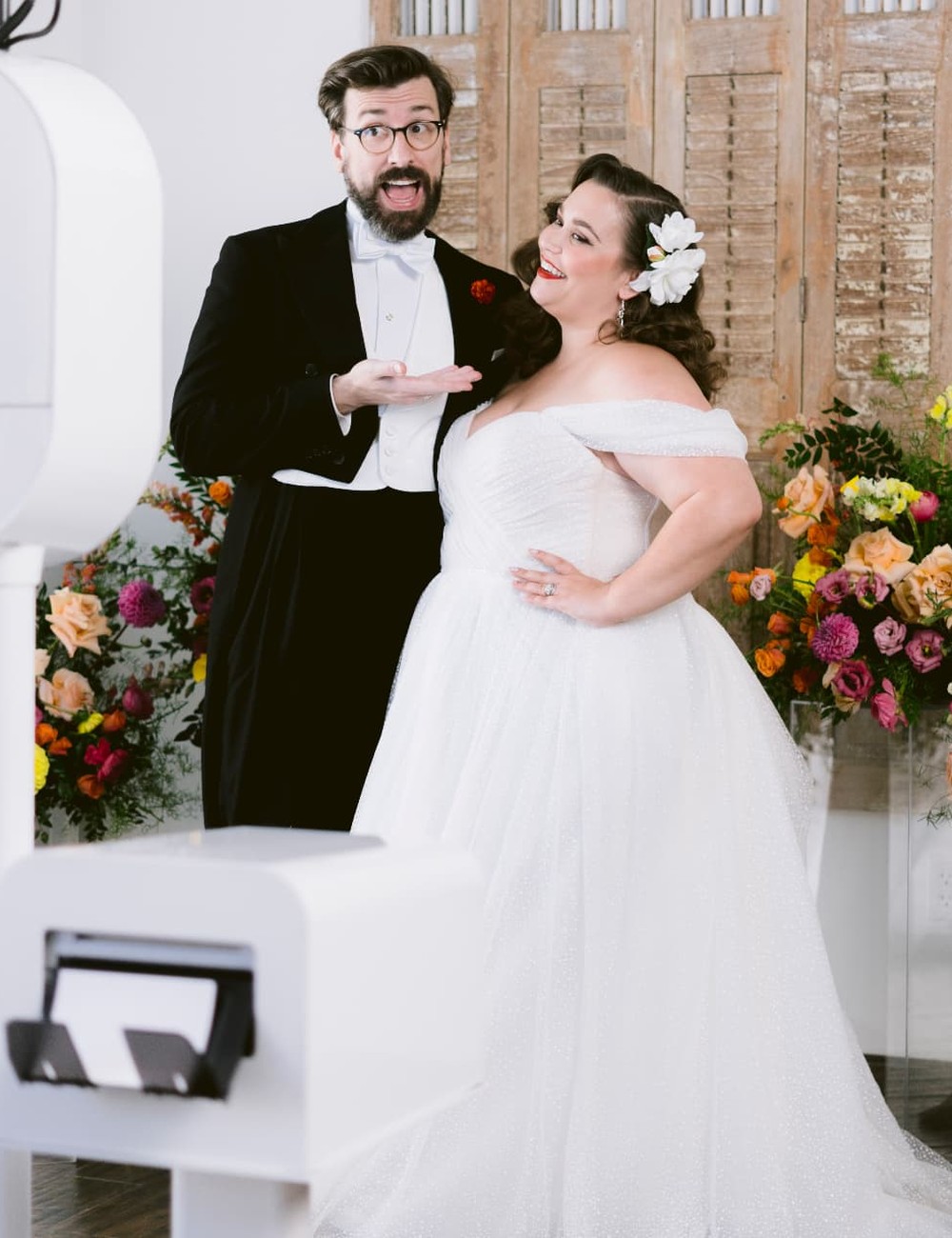 An attendant styling a minimalist photo booth in a softly lit venue