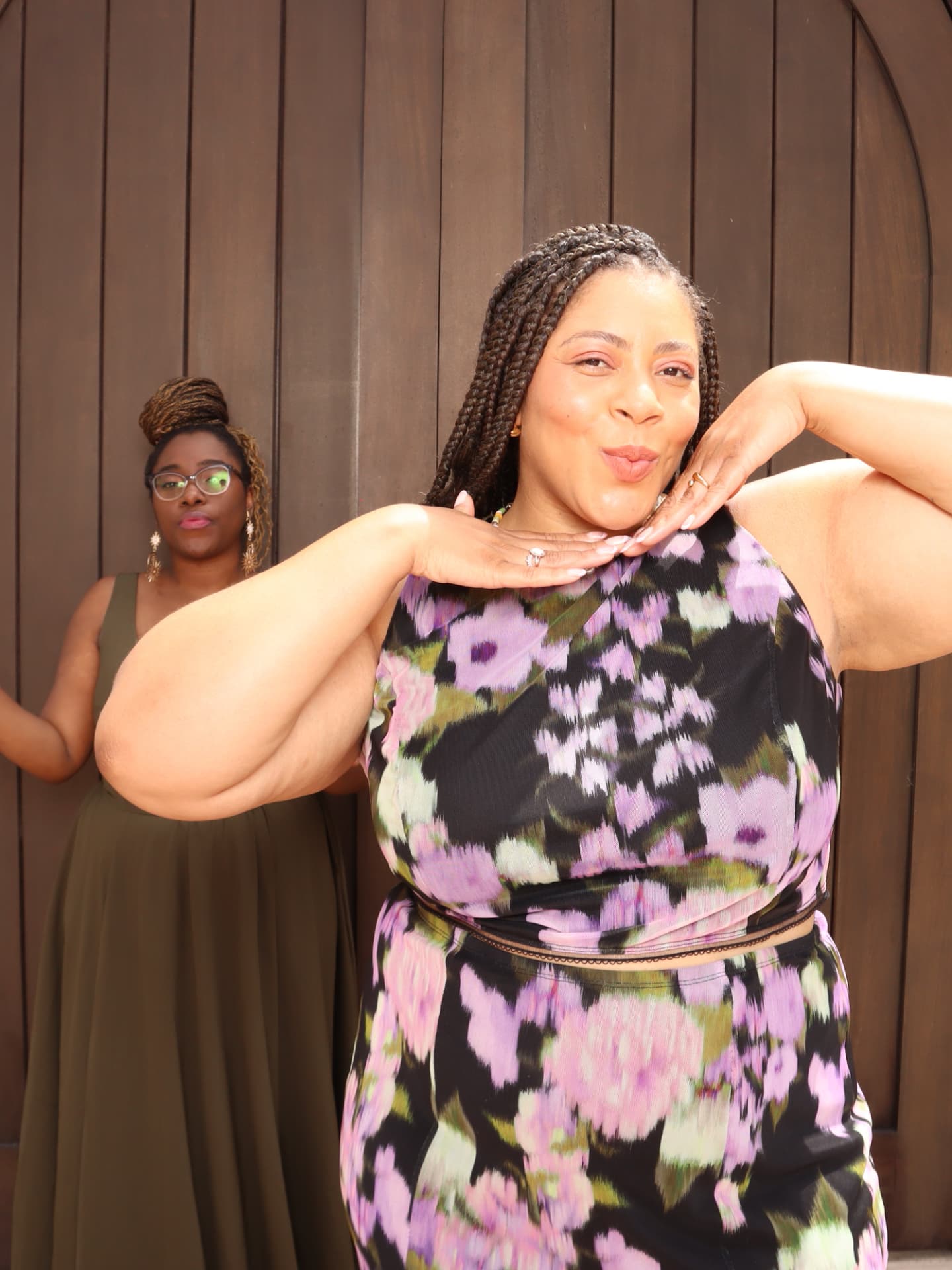 Guest blowing a kiss in front of an arched wood backdrop